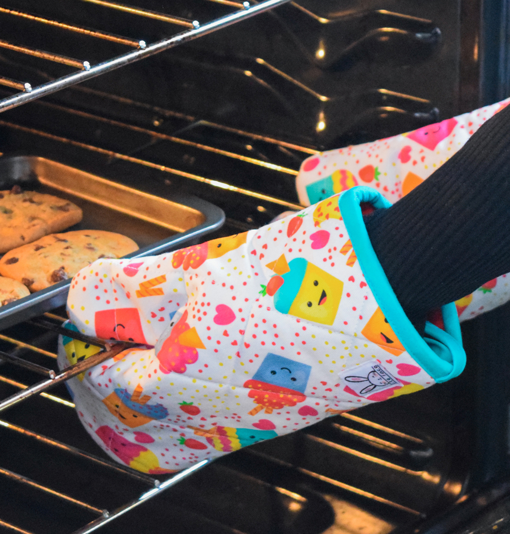 Les petites mitaines de four sont parfaites pour s'amuser et aider les parents à faire la cuisine en toute sécurité. Ensemble de deux. Isolées à double épaisseur. Ganse pour les accrocher sur un crochet. Fabriqué au Québec. Motif de petits cocktails amusant pour enfant.